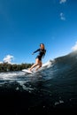 Happy young woman in swimsuit rides down the wave on surfboard Royalty Free Stock Photo