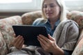 Happy young woman with tablet pc laying on sofa. Royalty Free Stock Photo