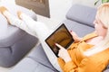 Happy young woman with tablet pc laying on sofa Royalty Free Stock Photo