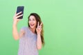 Happy young woman taking selfie with hand peace sign