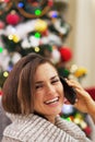 Happy young woman talking cell phone near christmas tree Royalty Free Stock Photo