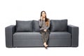 Happy young woman talking cell phone while sitting on sofa on white Royalty Free Stock Photo