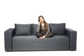 Happy young woman talking cell phone while sitting on sofa on white Royalty Free Stock Photo