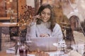 Happy young woman talking on her mobile phone and sitting in cafe Royalty Free Stock Photo