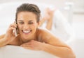 Happy young woman talking mobile phone while in bathtub Royalty Free Stock Photo