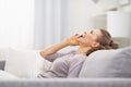 Happy young woman talking mobile phone while relaxing on couch Royalty Free Stock Photo