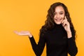 Happy young woman talking phone isolated over the yellow background. Royalty Free Stock Photo