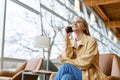 Happy young woman talking on phone making call sitting in coworking space. Royalty Free Stock Photo