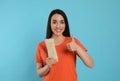 Happy woman with tasty shawarma showing thumb up on turquoise background