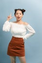 Happy young woman or teen girl in casual clothes  pointing finger up Royalty Free Stock Photo