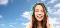 Happy young woman or teenage girl with headphones