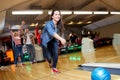 Happy young woman throwing ball in bowling club Royalty Free Stock Photo