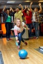 Happy young woman throwing ball in bowling club Royalty Free Stock Photo