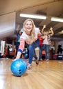 Happy young woman throwing ball in bowling club Royalty Free Stock Photo