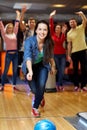 Happy young woman throwing ball in bowling club Royalty Free Stock Photo