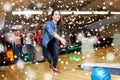 Happy young woman throwing ball in bowling club Royalty Free Stock Photo