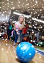 Happy young woman throwing ball in bowling club Royalty Free Stock Photo