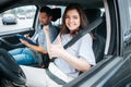 Happy young woman thumbing up. Female student smiles because of a successful driving test, looks at camera and pointing Royalty Free Stock Photo