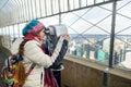 Happy young woman tourist at the observation deck of Empire State Building in New York City. Female traveler enjoying the view of