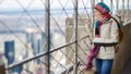 Happy young woman tourist at the observation deck of Empire State Building in New York City. Female traveler enjoying the view of Royalty Free Stock Photo