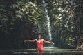 Happy Young woman tourist with straw hat in the deep jungle with waterfall. Real adventure concept. Bali island. Royalty Free Stock Photo