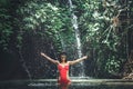 Happy Young woman tourist with straw hat in the deep jungle with waterfall. Real adventure concept. Bali island. Royalty Free Stock Photo
