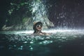 Happy young woman tourist swimming in the deep jungle with waterfall. Real adventure concept. Bali island. Royalty Free Stock Photo