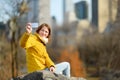 Happy young woman tourist taking pictures at Central Park in New York City. Female traveler enjoying views of downtown Manhattan. Royalty Free Stock Photo