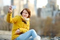 Happy young woman tourist taking pictures at Central Park in New York City. Female traveler enjoying views of downtown Manhattan. Royalty Free Stock Photo