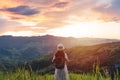 Happy young woman traveler relaxing and looking at the beautiful sunrise on the top of mountains, Travel lifestyle Royalty Free Stock Photo