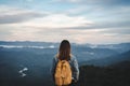 Happy young woman traveler relaxing and looking at the beautiful sunset on the top of mountain Royalty Free Stock Photo