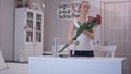 Happy young woman tying a ribbon bow on red rose bouquet and smelling it Royalty Free Stock Photo