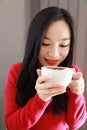 Happy young woman is under a blanket and cup of coffee on winter morning at home Royalty Free Stock Photo