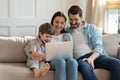 Happy young woman using computer with husband and small kid. Royalty Free Stock Photo