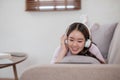 Happy young woman using laptop at home sitting on soft couch. Lady is working on laptop computer. Girl student is typing Royalty Free Stock Photo