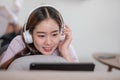 Happy young woman using laptop at home sitting on soft couch. Lady is working on laptop computer. Girl student is typing Royalty Free Stock Photo