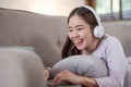 Happy young woman using laptop at home sitting on soft couch. Lady is working on laptop computer. Girl student is typing Royalty Free Stock Photo