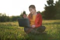 Happy young woman using laptop outdoors in summer nature, video call concept. Royalty Free Stock Photo