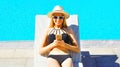 happy young woman using smartphone lying on deckchair over blue water pool background Royalty Free Stock Photo