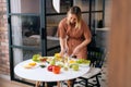 Happy young woman vegetarian prepare salad meal alone at home. Royalty Free Stock Photo