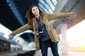 Happy young woman waitng train on the railway station platform. Royalty Free Stock Photo