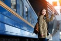 Happy young woman waitng train on the railway station platform. Woman travel with the train. Royalty Free Stock Photo
