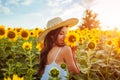Young woman walking in blooming sunflower field and smelling flowers. Summer vacation Royalty Free Stock Photo