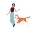 Happy young woman walking with dog. Pet owner leading her Akita-Inu doggy on leash. Female character and purebred