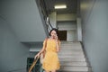 Happy young woman walking downstairs, talking on mobile phone Royalty Free Stock Photo