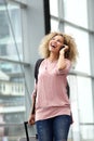 Happy young woman walking with suitcase and mobile phone Royalty Free Stock Photo