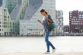 Happy young woman walking water in city with mobile phone Royalty Free Stock Photo