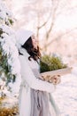 Happy young woman walks in winter forest among trees in sunny day Royalty Free Stock Photo