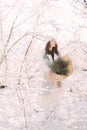 Happy young woman walks in winter forest among trees in sunny day Royalty Free Stock Photo
