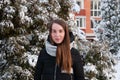 Woman in winter down jacket in winter park on background of snow-covered fir Royalty Free Stock Photo